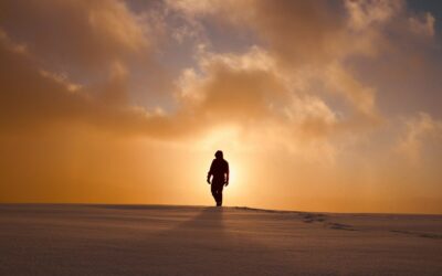 a person walking across a snow covered field